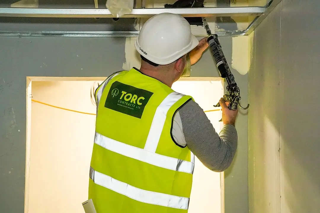 Torc Contracts employee using a sealant gun